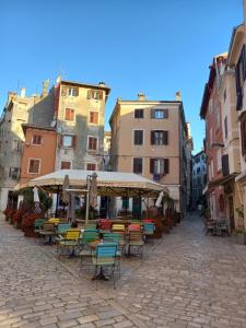 een lege straat met stoelen, tafels en gebouwen bij Bunari Studio Apartment in Rovinj