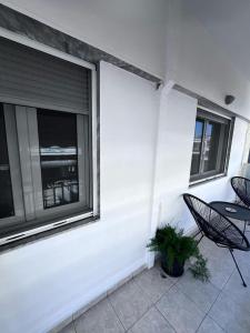 a patio with two chairs and a table and two windows at HARBOR house in Kavála