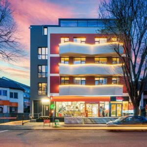 a tall building with a sunset in the background at URBAN BUDGET HOTEL in Timişoara