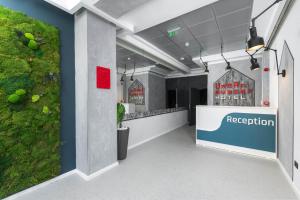 a reception area of a restaurant with a green wall at URBAN BUDGET HOTEL in Timişoara