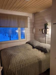 1 dormitorio con 1 cama grande y ventana en Unelmasäleikkö 2 en Kittilä