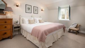 a bedroom with a large white bed and a chair at The Coach House, Pentland Hills in Nine Mile Burn