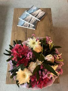 een boeket bloemen op een tafel met een tijdschrift bij SleepWell in Valganna in Valganna