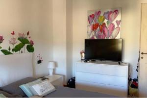 a living room with a flat screen tv on a dresser at Villa a 2 piani vicino al mare in Villasimius