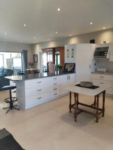 uma cozinha com armários brancos e uma mesa em Intimi2 em Yzerfontein