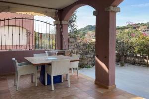 a patio with a table and chairs on a balcony at Villa a 2 piani vicino al mare in Villasimius