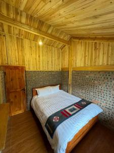 a bedroom with a bed in a wooden room at Chacha's House in Sapa