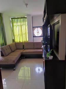 a living room with a couch and a television at Apartamento Vallejo in Trujillo