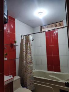 a bathroom with a tub and a shower curtain at Apartamento Vallejo in Trujillo