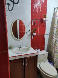 a bathroom with a sink and a toilet and a mirror at Apartamento Vallejo in Trujillo