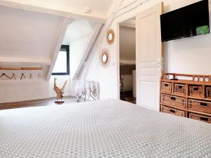una camera con un grande letto e una TV a schermo piatto di Maison de 2 chambres avec jardin clos et wifi a Sainte Genevieve les Gasny a Sainte-Geneviève-lès-Gasny