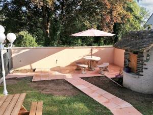 patio con tavolo e ombrellone di Maison de 2 chambres avec jardin clos et wifi a Sainte Genevieve les Gasny a Sainte-Geneviève-lès-Gasny