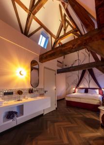 a bedroom with a king sized bed and a bathroom at Relais & Châteaux Weeshuis Gouda in Gouda