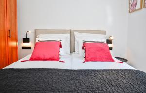 1 cama grande con 2 almohadas rojas. en Zografou luxury apartment 1 bedroom 4 pers by MPS, en Atenas