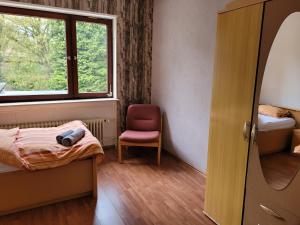 een kamer met een bed, een raam en een stoel bij Haus mit Garten mitten im Kurpark für Monteure und Urlauber, 140 qm in Bad Salzschlirf