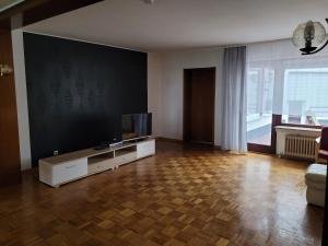a living room with a flat screen tv sitting on a cabinet at Haus mit Garten mitten im Kurpark für Monteure und Urlauber, 140 qm in Bad Salzschlirf