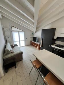 a kitchen with a couch and a table in a room at Mansarda Polpetta in Corsico