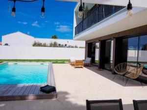 a house with a swimming pool and a patio at Beautiful Villa close to the Seaside in Talmont