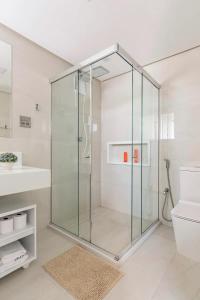 a glass shower in a bathroom with a sink at Amplo apartamento Barra Salvador in Salvador