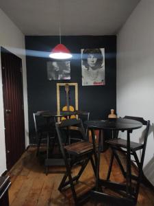 a dining room with two black tables and chairs at Casa de 3 quartos in Resende