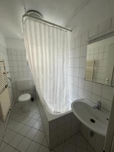 a white bathroom with a toilet and a sink at HOSTEL Bahnhof in Frankfurt