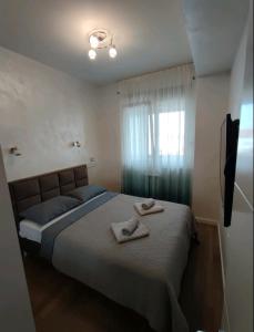 a bedroom with a bed with two towels on it at Ada Luxury Apartment in Čukarica