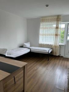 two beds in a room with a window at HOSTEL Bahnhof in Frankfurt