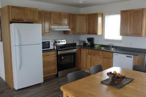 cocina con nevera blanca y armarios de madera en Wood Duck Cottage en Cavendish