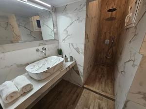 a bathroom with a sink and a shower at 53 Central Luxury Apartment in Thessaloniki