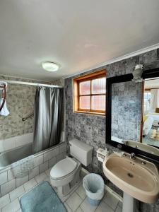 uma casa de banho com um WC, um lavatório e uma banheira em Hotel Casa Kolping em Castro