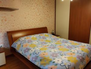 a bed with a floral comforter in a bedroom at Border House in Gorizia