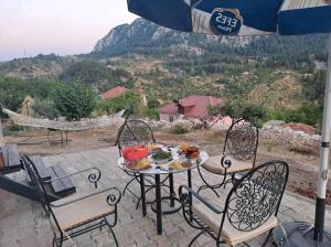 a table and chairs with food on a patio at Canerbey Çiftlik in Ovacık
