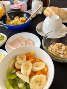 a table topped with a bowl of fruit and cereal at Hotel Casa Kolping in Castro