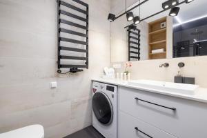 a laundry room with a washing machine and a sink at Bright Apartment in Kraków with Garden, Air Conditioning, Parking and Desk by Renters Prestige in Kraków