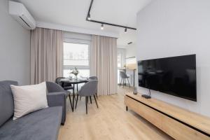 a living room with a large flat screen tv at Bright Apartment in Kraków with Garden, Air Conditioning, Parking and Desk by Renters Prestige in Kraków