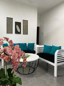 sala de estar con sofá, mesa y flores en Cinnamon Apartment Panadura 2, en Panadura