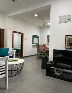 sala de estar con sofá, mesa y TV en Cinnamon Apartment Panadura 2, en Panadura