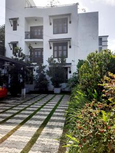 un edificio blanco con algunas plantas delante de él en Cinnamon Apartment Panadura 2, en Panadura