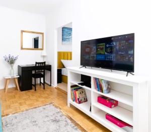 a living room with a television on a white entertainment center at Apartman Čuić in Vinkovci