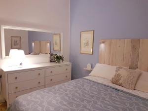 a bedroom with a bed with a dresser and a mirror at Il Cuore di Santa è tutto blu in Santa Margherita Ligure