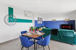 une salle à manger avec une table et des chaises bleues dans l'établissement Stylish Gem Of Chelmsford with Balcony, à Chelmsford