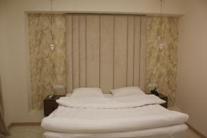 uma cama num quarto com duas mesas de cabeceira e sidx sidx em Lux Plaza Hotel em Arbatʼ