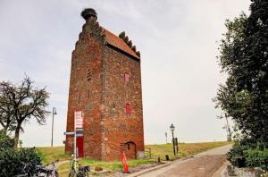 a brick building on a hill next to a road at B&B Op de Keien in Megen