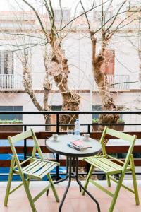 stół i 2 krzesła na balkonie z drzewem w obiekcie La Marmora w mieście Alghero