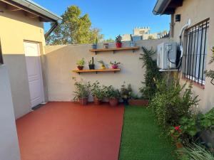 un jardin avec des plantes en pot sur le côté d'un bâtiment dans l'établissement Departamento en Campana, à Campana