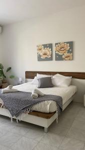 uma cama num quarto com duas fotografias na parede em Bright and spacious Double Room, shared bathroom em Tal-Għoqod