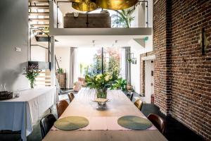 une salle à manger avec une table et un mur en briques dans l'établissement Vakantiewoning De Woestijn, à Roosdaal