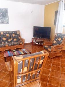 a living room with couches and a flat screen tv at Maison de 3 chambres avec jardin amenage et wifi a Pointe Noire a 1 km de la plage in Pointe-Noire