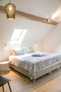 1 dormitorio con 1 cama grande y ventana en Vakantiewoning De Woestijn, en Roosdaal