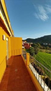 a balcony of a yellow building with a fence at Villa La Flor de Anaga in Las Lagunas
